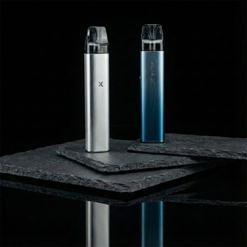 Zwei Elfx Pod-Systeme auf schwarzem Schieferstein - links silbernes Elfx Modell, rechts blaugrünes Elfx Pro Modell