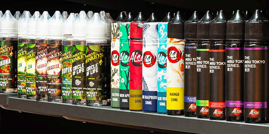 Vape- und Liquid-Regal im Smokee Baden Nahaufnahme eines Regals mit zahlreichen E-Liquids und Nikotinsalzen im Smokee Baden, darunter Marken wie Twelve Monkeys, Aisu oder Dinner Lady.